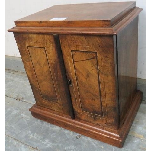 852 - A Victorian figured walnut table top cabinet, the twin doors with ebony and satinwood inlay, opening... 