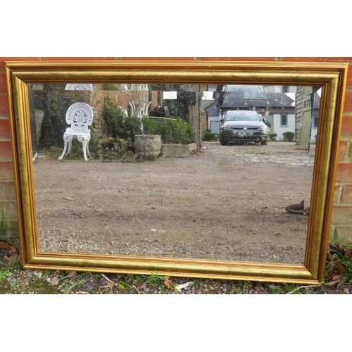 855 - A rectangular bevelled wall mirror, having a moulded gilt frame with distressed effect. 
H69cm W99cm... 