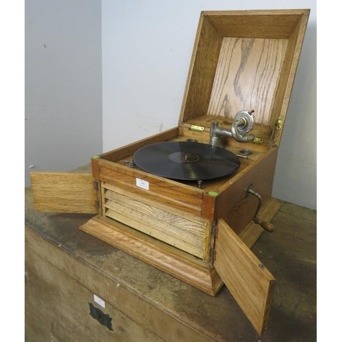 860 - An early 20th century light oak cased tabletop gramophone by Karna, together with approximately 50 r... 