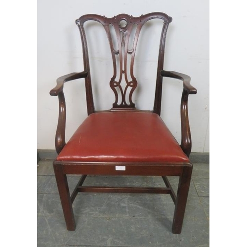 869 - A Georgian mahogany elbow chair in the manner of Chippendale, having carved and pierced back, above ... 