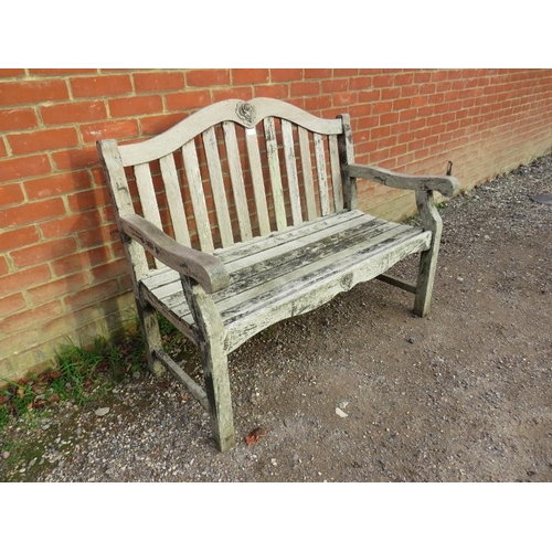 889 - A weathered teak two-seater slatted garden bench, with relief carved rose decoration, on square supp... 