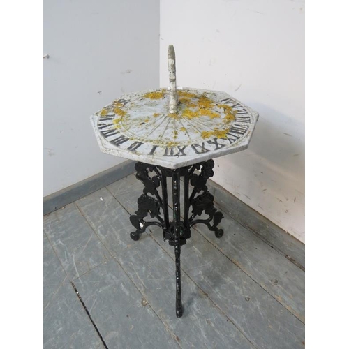 891 - A vintage cast iron sundial, the top painted grey with contrasting Roman numerals, on a pierced trip... 