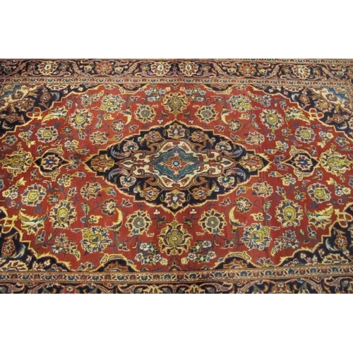 901 - A fine central Persian Kashan rug. Central floral design blue on red ground. In very good condition.... 