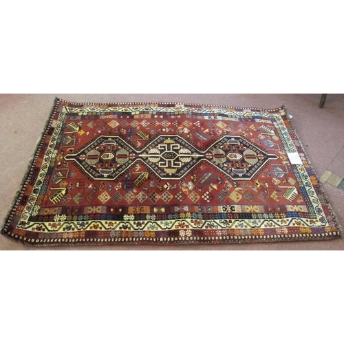 903 - A good South West Persian Qashqai rug in central motif of three interlocking panels on a soft red gr... 