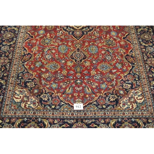 912 - A good central Persian Kashan carpet central motif blue/cream on a floral red ground, with very wide... 