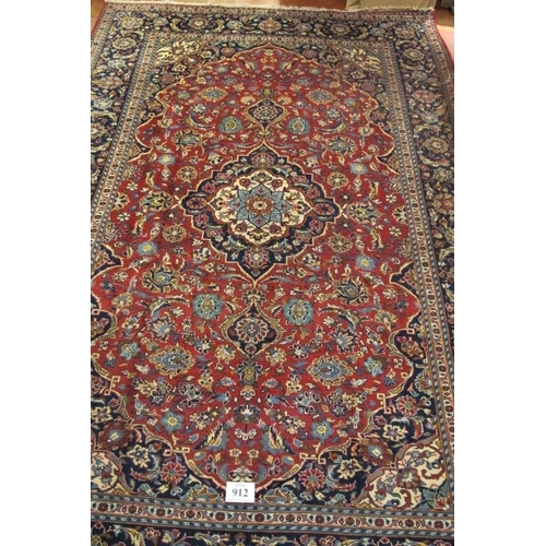 912 - A good central Persian Kashan carpet central motif blue/cream on a floral red ground, with very wide... 