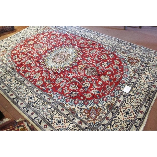 913 - A Persian rung, central motif on red ground and wide blue & cream borders. Very clean rug. 294cm x 2... 