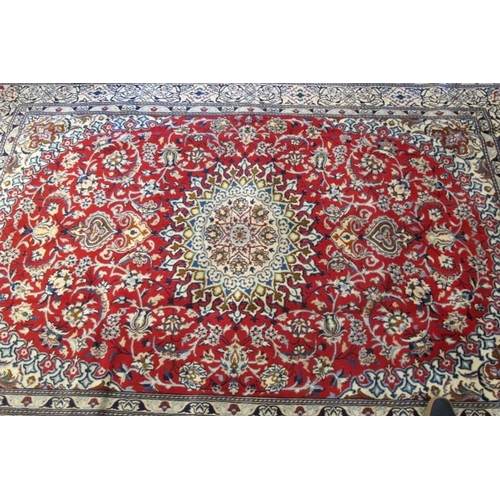 913 - A Persian rung, central motif on red ground and wide blue & cream borders. Very clean rug. 294cm x 2... 