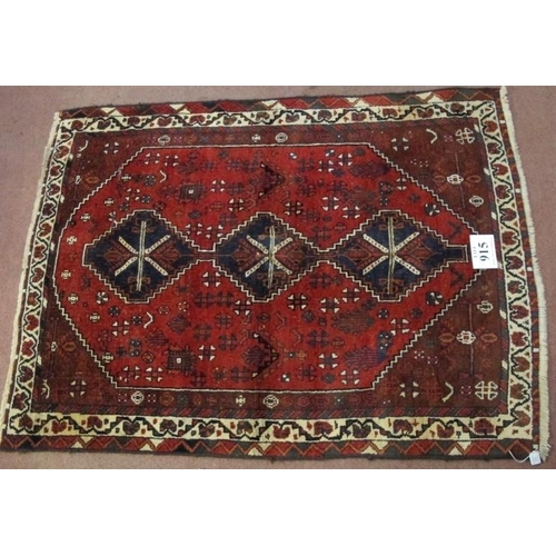 915 - A mid 20th century Persian rug, three central linked medallions on a deep red ground, in good condit... 