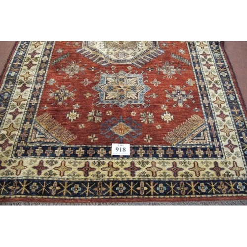 918 - A good quality late 20th century wooley rug. One large central motif and 12 smaller on a terracotta ... 