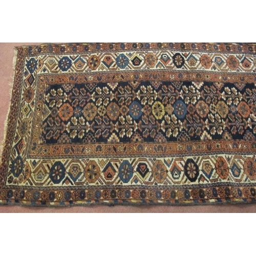 920 - A late 19th/early 20th century Persian rug. A central block repeat pattern on black ground with trip... 