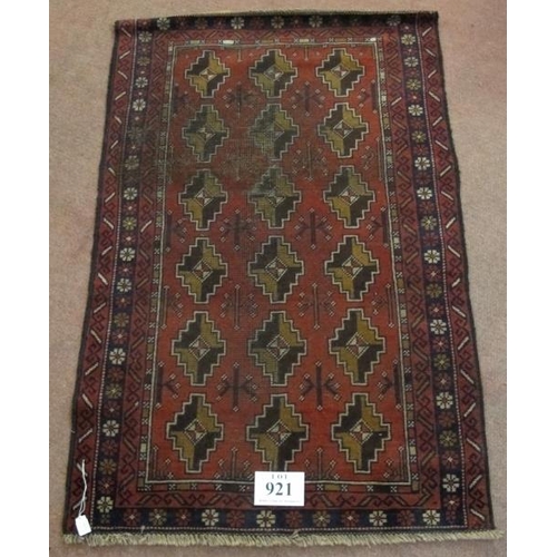 921 - A mid 20th century Persian rug, repeat central pattern on red ground. Slight colour variation. See i... 