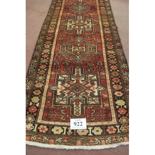 922 - A 20th century Persian runner, seven large central motifs on a red ground. Colour and condition good... 