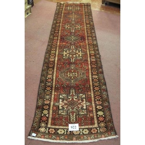 922 - A 20th century Persian runner, seven large central motifs on a red ground. Colour and condition good... 