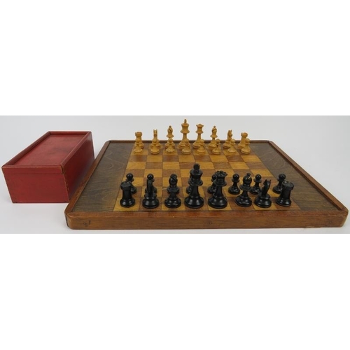 154 - A vintage turned and ebonised holly wood chess set and a stained oak chessboard, mid/late 20th centu... 