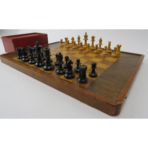 154 - A vintage turned and ebonised holly wood chess set and a stained oak chessboard, mid/late 20th centu... 