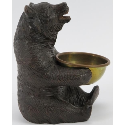 17 - A finely carved Black Forest bear holding a brass bowl. Modelled with glass eyes. Possibly to be uti... 