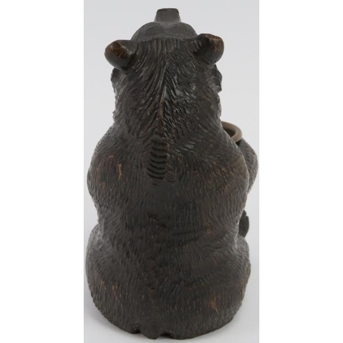 17 - A finely carved Black Forest bear holding a brass bowl. Modelled with glass eyes. Possibly to be uti... 