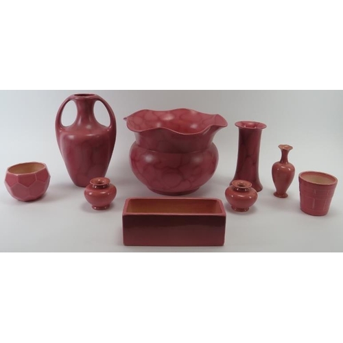 241 - A group of Bretby pink glazed ceramic wares, early 20th century. Items include a jardiniere, a plant... 