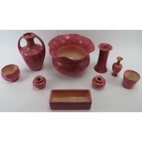 241 - A group of Bretby pink glazed ceramic wares, early 20th century. Items include a jardiniere, a plant... 