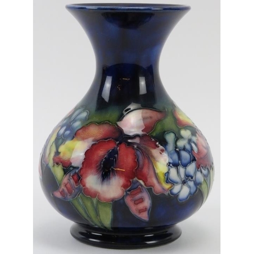 255 - A Walter Moorcroft Orchid pattern vase, circa 1940s. Tubeline decorated with Orchids against a blue ... 