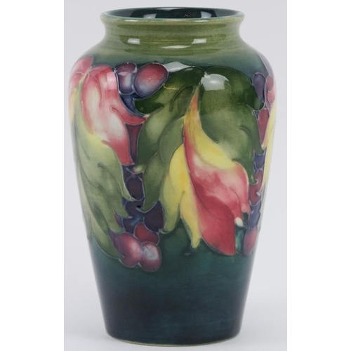 257 - A William Moorcroft Leaf and Berry pattern vase, circa 1928 - 1935. Tubeline decorated with leaves a... 