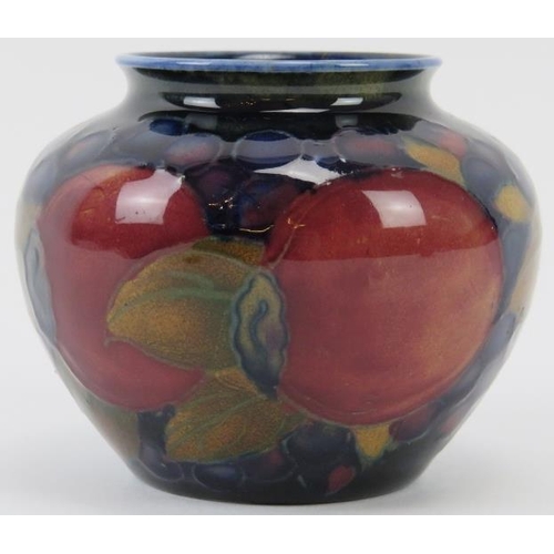 258 - A William Moorcroft Pomegranate pattern vase, circa 1913 - 1925. Tubeline decorated with leaves and ... 