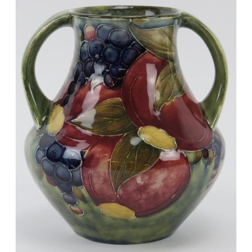 297 - A William Moorcroft Pomegranate pattern twin handled vase, circa 1914. Signed ‘W. Moorcroft 1914’ in... 