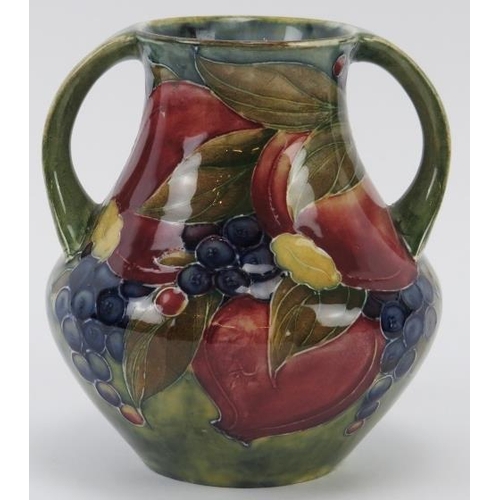 297 - A William Moorcroft Pomegranate pattern twin handled vase, circa 1914. Signed ‘W. Moorcroft 1914’ in... 