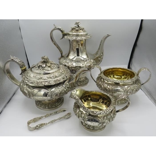 302 - A Georgian heavily embossed silver teapot, sugar bowl & cream jug, sitting on a pedestal base and de... 