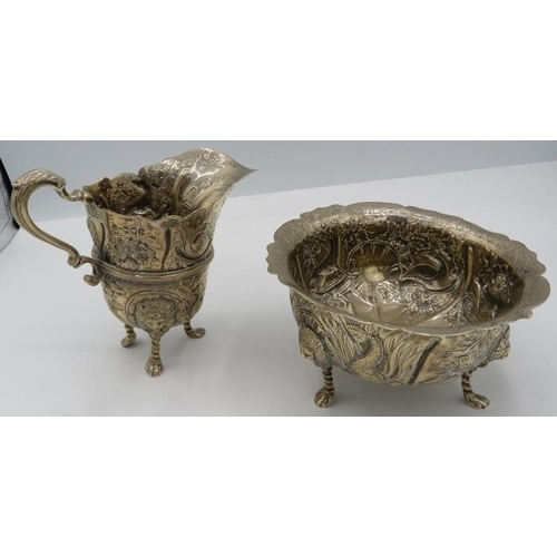 310 - A heavily embossed cream jug and sugar bowl decorated with panels of animals & lion masks, London 18... 