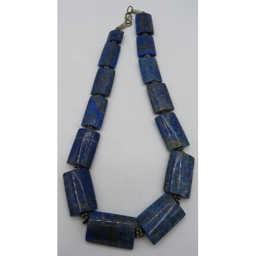 327 - A lapis lazuli necklace with small white metal spacers and hook clasp. Approx weight 105 grams.
Cond... 