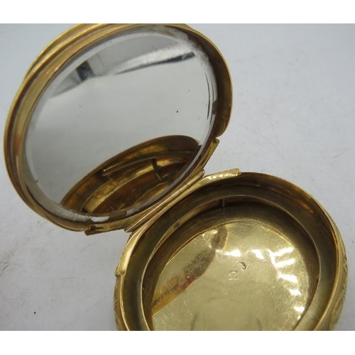 337 - A French gold engraved oval snuff box/compact with interior mirrored glass. A centre urn decorates t... 