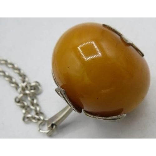 384 - An apple type amber pendant, approx 35mm across, with white metal mounts on a silver 925 chain and a... 