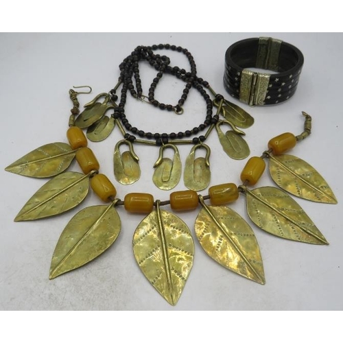 386 - A Middle Eastern amber & brass necklace having eight oblong amber beads and seven brass leaves. Each... 