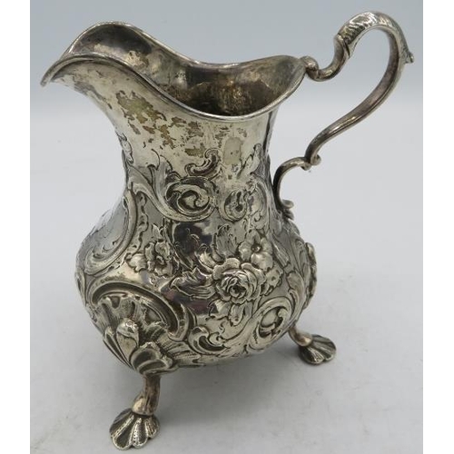 393 - A Victorian silver jug on splayed feet, double scrolled acanthus leaf handle and heavily embossed wi... 