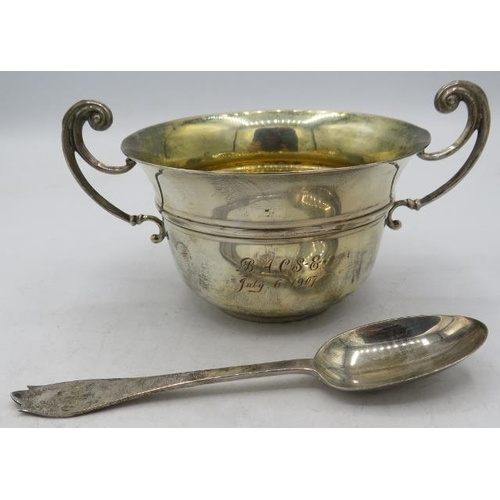 394 - A silver porringer with gilded interior and matching silver spoon. Engraved on the side, London 1906... 