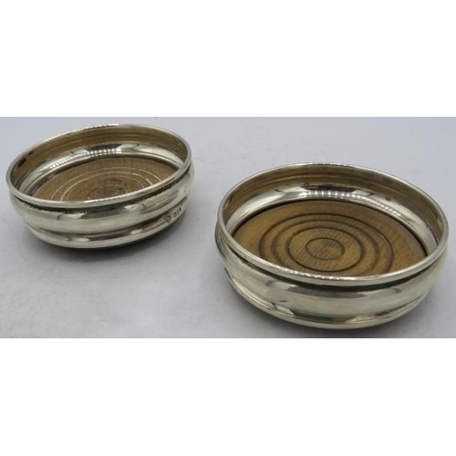 396 - A pair of small silver coasters with wooden bases, London 1968. Approx weight 3 troy oz/93 grams.
Co... 