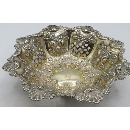 397 - An octagonal silver bon bon dish. Heavily embossed with fruit & flowers, pierced openwork on four of... 