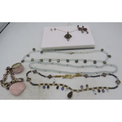 404 - A white metal pendant set with a group of semi-precious stones including garnets, amethyst & topaz i... 