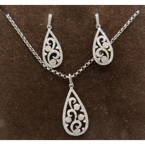 409 - A fine pear shaped 9ct white gold pendant with openwork floral design encrusted with diamonds on a f... 