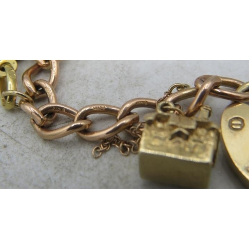 417 - A 9ct gold link charm bracelet with 9ct gold padlock clasp and ten charms. (Four 9ct gold charms, tw... 