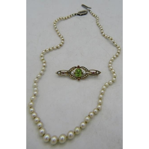 421 - A peridot, ruby & seed pearl yellow metal bar brooch and a strand of small graduated pearls with whi... 