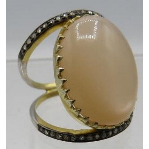 458 - A yellow & white metal ring set with large oval cabochon moonstone & two bands of small rose cut dia... 