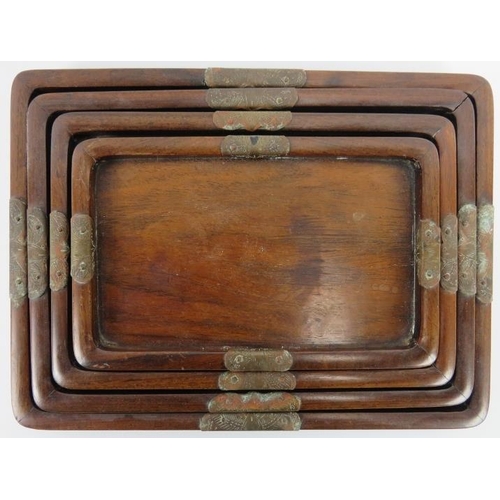 46 - A set of four Chinese graduated rosewood trays, early 20th century. Mounted with engraved brass butt... 