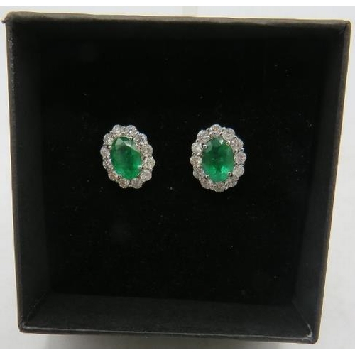 464 - A pair of 18ct white gold oval emerald & RBC diamond cluster stud earrings. Emeralds approx 1.33cts,... 