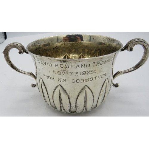 472 - A heavy silver porringer with leaf type embossed decoration, Birmingham 1929, engraved 'From Godmoth... 