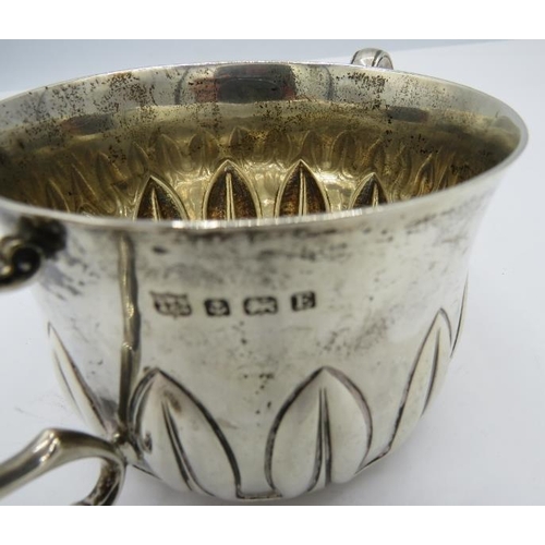 472 - A heavy silver porringer with leaf type embossed decoration, Birmingham 1929, engraved 'From Godmoth... 