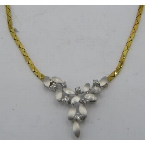 500 - An 18ct yellow & white gold delicate necklace. The centre design having leaf decoration and set with... 