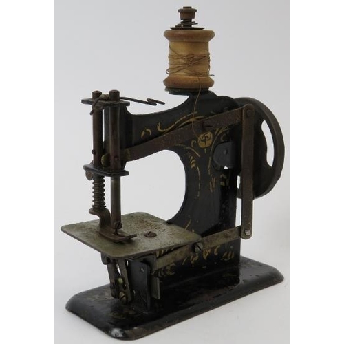 86 - A vintage child’s miniature tinplate toy sewing machine, early 20th century. Probably German, the pl... 